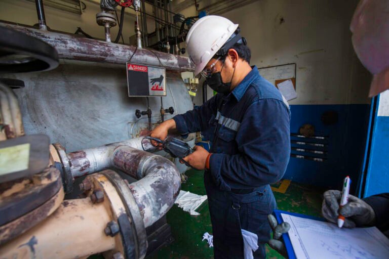 Male two worker inspection measured the coil pipeline thickness