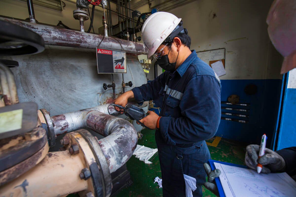 Male two worker inspection measured the coil pipeline thickness