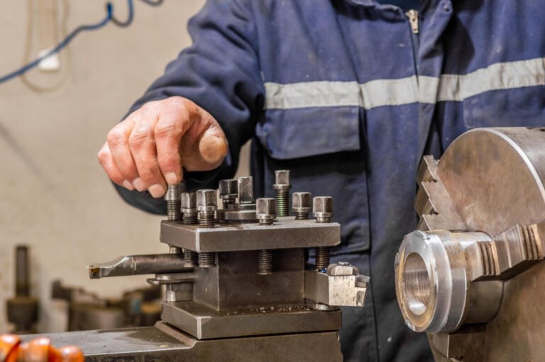 Heavy industrial worker operator working with lathe machine